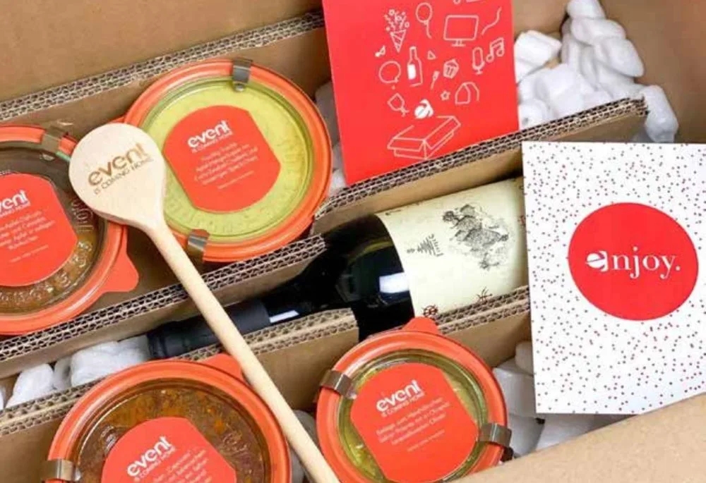 Geschenkbox mit Gläsern, Kochlöffel und Karten im roten event-Design
